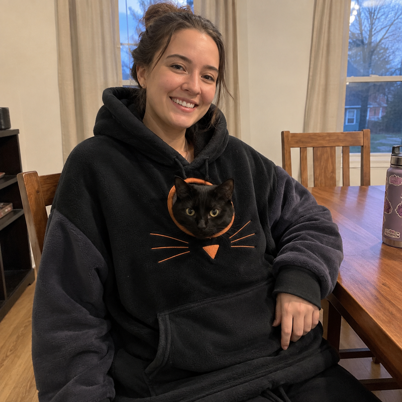 Anna W. wearing the hoodie with their cat